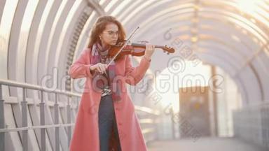 在头顶的通道上拉小提琴的年轻女子